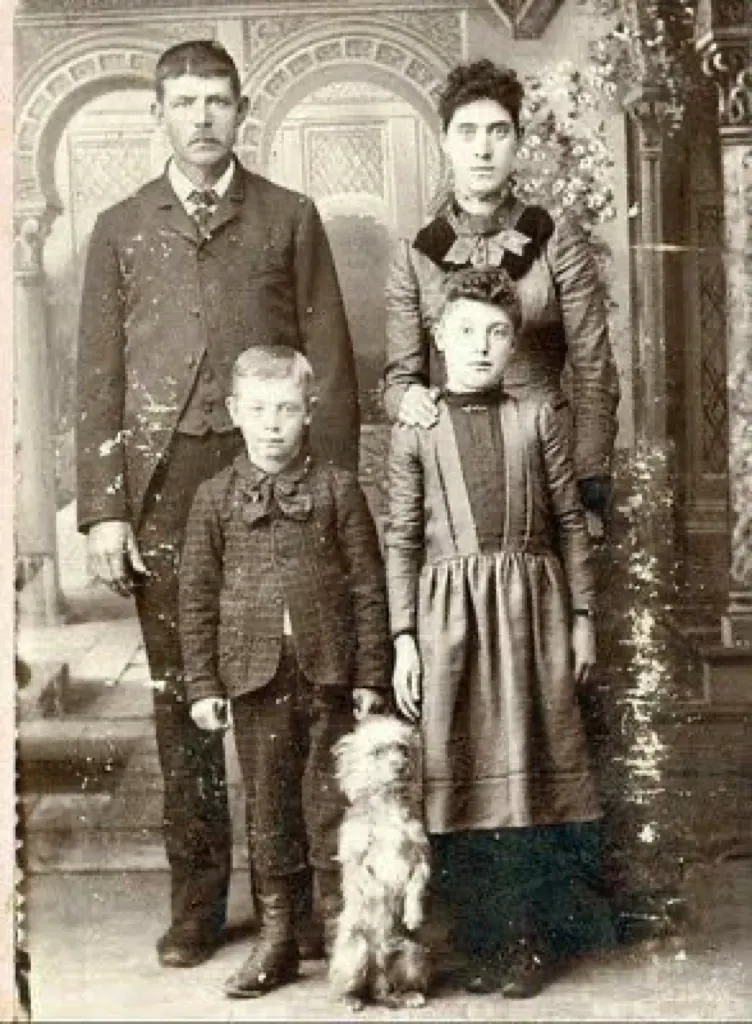 Faded sepia family portrait with a dog, before restoration