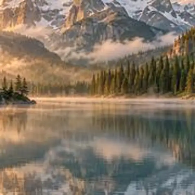 A small, pixelated photo of an autumn river valley with a cabin